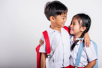 亚洲学生孩子女孩男孩小学生哥哥妹妹微笑快乐穿学生泰国统一的红色的裤子裙子拥抱