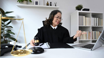 成熟的女律师袍礼服统一的坐着前面移动PC提供<strong>法律咨询法律</strong>建议在线
