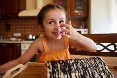 有趣的高加索人婴儿女孩坐着餐厅表格服务自制的蛋糕甜点修道院小屋