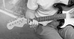 黑色的白色照片年轻的的家伙玩吉他特写镜头焦点手指