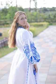 肖像年轻的女人穿蓝色的国家传统的绣花衬衫漂亮的女孩户外穿着爱国衣服