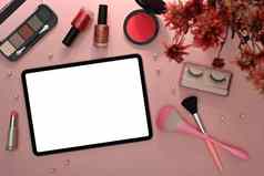 数字平板电脑化妆刷化妆品花粉红色的背景平躺前视图