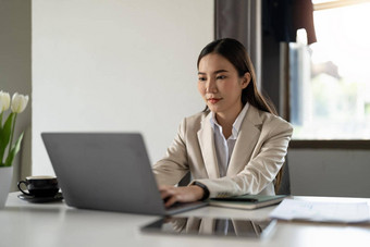 肖像快乐千禧亚洲女商人工作移动PC在线首页办公室微笑年轻的女人员工工人咨询客户端合作伙伴遥远的电脑技术概念