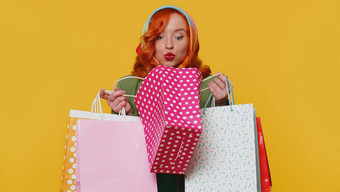 购物狂时尚的年轻的女人显示购物袋广告折扣低价格假期