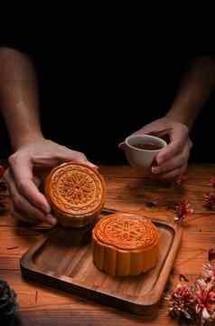 手持有传统的月饼杯茶中期秋天节日中国人传统的节日
