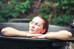 女人享受水疗中心热浴缸在户外