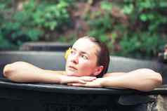 女人享受水疗中心热浴缸在户外