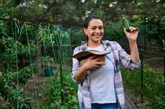 迷人的女人园丁持有新鲜选成熟的黄瓜农场未来素食主义者洛娃保存地球