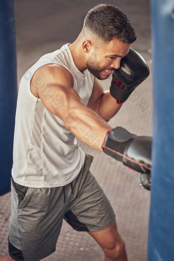 拳击手打穿孔袋健身房强大的综合格斗战斗机冲健身房战斗战斗机有氧运动培训健身房肌肉发达的运动员拳击实践健身房适合男人。权力穿孔
