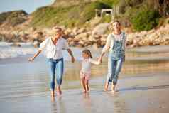可爱的高加索人女孩举行妈妈祖母海海滩年轻的女人妈妈持有可爱的女儿走水海岸日落