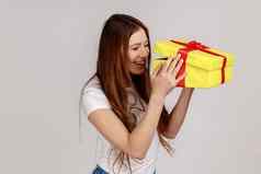 女人unboxing黄色的礼物盒子内部积极的面部表达式生日现在