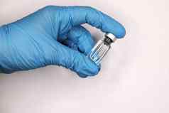 手蓝色的医疗手套特写镜头持有疫苗光背景概念战斗科维德