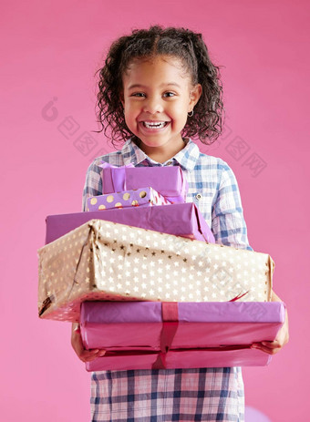 漂亮的混合比赛女孩卷曲的头发持有堆栈包装礼物粉红色的Copyspace背景工作室非洲孩子兴奋礼物生日