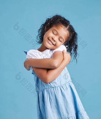 可爱的可爱的女孩快乐拥抱拥抱可爱的孩子积极的自尊蓝色的工作室背景