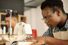 集中设计师缝纫织物集中裁缝缝纫机非洲美国设计师缝纫一块牛仔布年轻的商人工作缝纫机裁缝缝纫服装