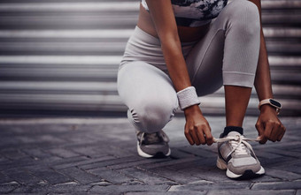 特写镜头混合比赛女人系鞋带锻炼在户外运动员紧固运动鞋鞋子舒适的适合防止脱扣准备好了有氧运动培训锻炼运行城市