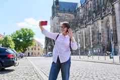 女人旅游采取自拍前面古老的欧洲大教堂