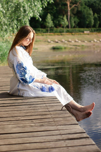 女孩绣花乌克兰衬衫坐在码头反射云水湖海岸天空维希万卡一天自由<strong>爱国</strong>者