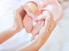 妈妈。持有婴儿脚特写镜头小新生儿婴儿脚举行父小婴儿脚趾婴儿说谎床上女人持有脚婴儿女孩无辜的婴儿举行妈妈。