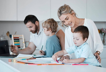 年轻的高加索人家庭在家教育孩子们爱的父母帮助孩子们家庭作业妈妈爸爸教学孩子们写读画