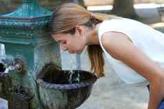 肖像年轻的女人水合物喝水喷泉热波夏天