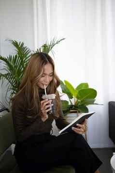 休闲亚洲女人喝冰咖啡阅读书咖啡商店
