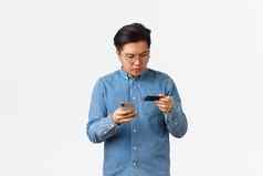 集中亚洲的家伙眼镜打字信贷卡数量使在线购买移动电话银行账户买互联网商店站白色背景