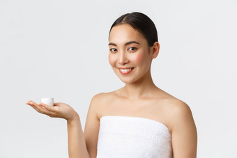 美个人护理水疗中心沙龙护肤品概念特写镜头美丽的亚洲女人浴毛巾介绍面部奶油保湿保湿治疗脸皮肤滋养