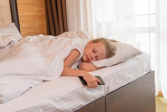 睡眠年轻的女孩美丽的电话移动床上毯子眼睛卧室概念白色细胞梦想平静床上<strong>用品</strong>健康的美在室内舒适的放松