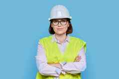 肖像女工业工人保护头盔背心蓝色的背景