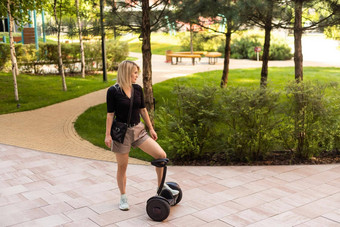 女人骑电迷你赛格威徘徊董事会踏板车绿色公园好夏天天气生态城市运输技术漂亮的模型电自动平衡踏板车董事会