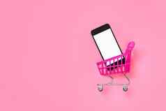 数字购物粉红色的概念销售移动在线购物电车孤立的屏幕智能手机模型商店在线超市车电话模型移动购物车孤立的粉红色的背景