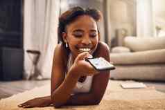 女孩发短信聊天浏览社会媒体电话放松首页年轻的女人搜索在线应用程序享受免费的时间有趣的应用程序生活房间地板上