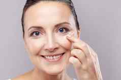 女人适用于脸奶油享受反皱纹化妆品产品穿最小的化妆