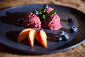 食物生活让人耳目一新素食主义者蓝莓冰沙融化海军蓝色的板超过薄荷叶子多汁的桃子