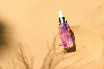 平躺抗衰老血清胶原蛋白肽光紫罗兰色的玻璃瓶下降桑迪背景