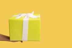 女人手持有黄色的礼物盒子丝带给现在假期奖金惊喜