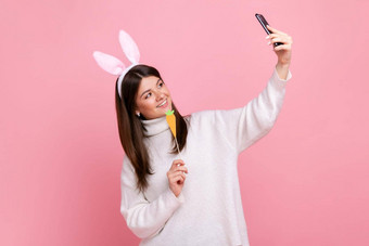 一边视图肖像有趣的女孩兔子耳朵流媒体视频调用胡萝卜手
