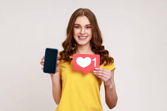 积极的微笑青少年女孩博主持有图标显示智能手机空白屏幕使帖子社会网络等待反馈
