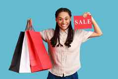 女人持有购物袋显示出售卡广告低价格购物中心