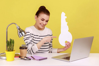 女人指出纸关键移动PC屏幕露出牙齿的微笑坐着工作场所