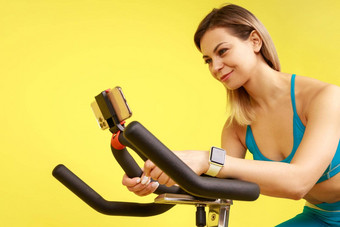 女人骑锻炼自行车移动电话广播有氧运动锻炼在线
