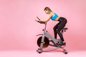 运动女人有氧运动锻炼在线骑锻炼自行车流媒体培训