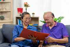 高级亚洲夫妇会说话的快乐规划退休保险健康护理合同沙发