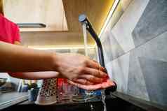 女孩洗手运行水黑色的盥洗盆水水龙头清洁菜木厨房家具