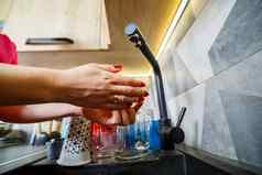 女孩洗手运行水黑色的盥洗盆水水龙头清洁菜木厨房家具