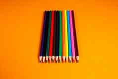 五彩缤纷的铅笔画堆放橙色背景文具项目