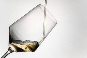 特写镜头倒白色酒水晶玻璃填充白色酒水晶玻璃孤立的灰色背景图像减少饮料概念