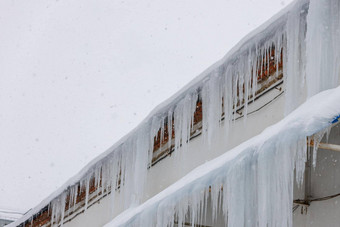 行冰柱挂屋顶边缘冬天一天降雪