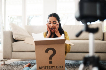 不错的惊喜有吸引力的年轻的女商人坐着生活房间视频博客反应神秘盒子
